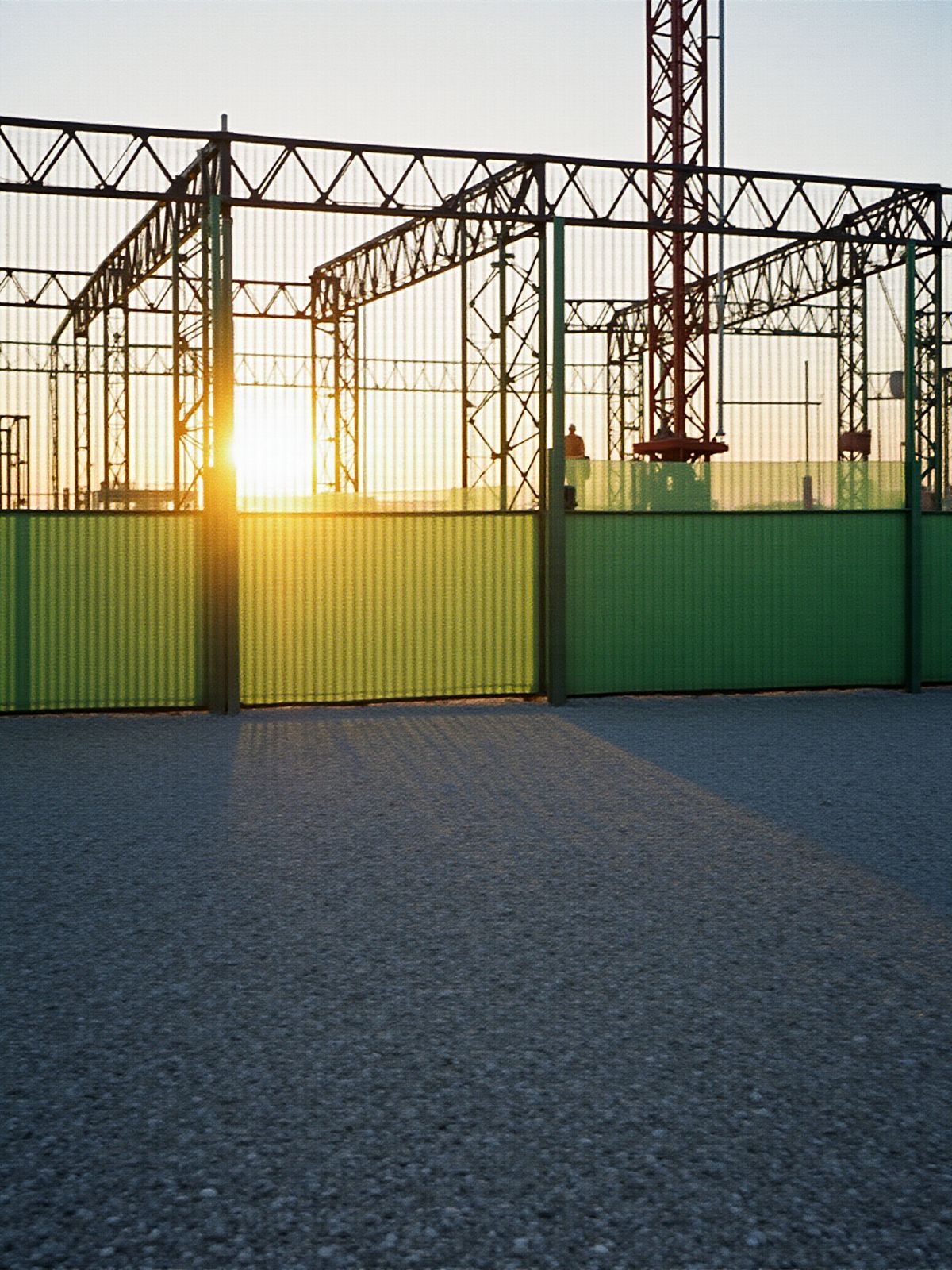 Pórticos metálicos sobre una cancha al atardecer