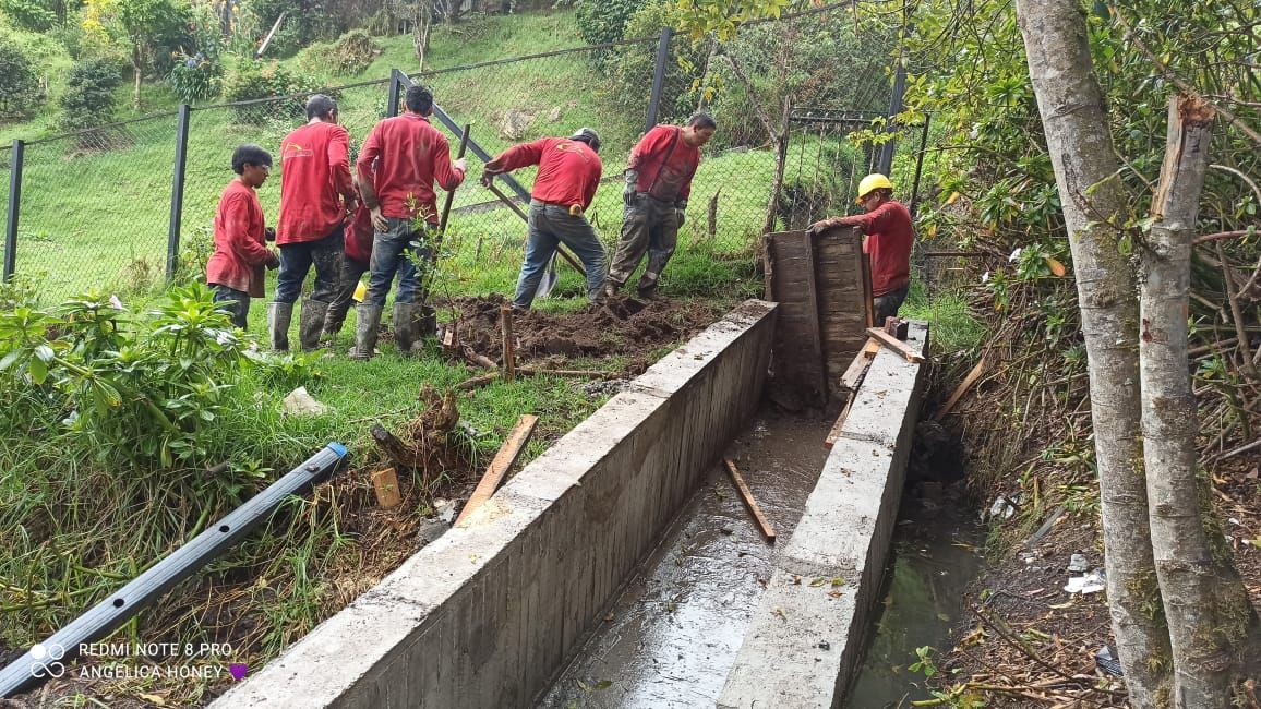 Cuadrilla construyendo un canal de concreto para aguas lluvias